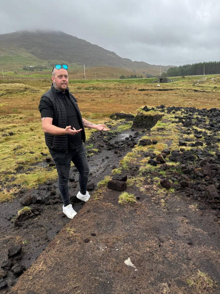 Guide gestures while standing on a peat bog landscape in rural Ireland