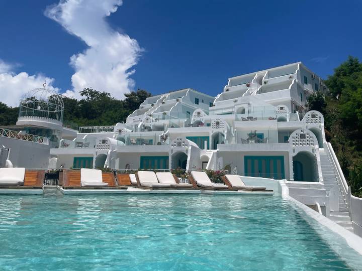 White terraced resort with turquoise swimming pool under clear blue Komodo sky