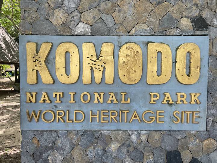 Stone monument bearing gold letters reading 'Komodo National Park World Heritage Site'.