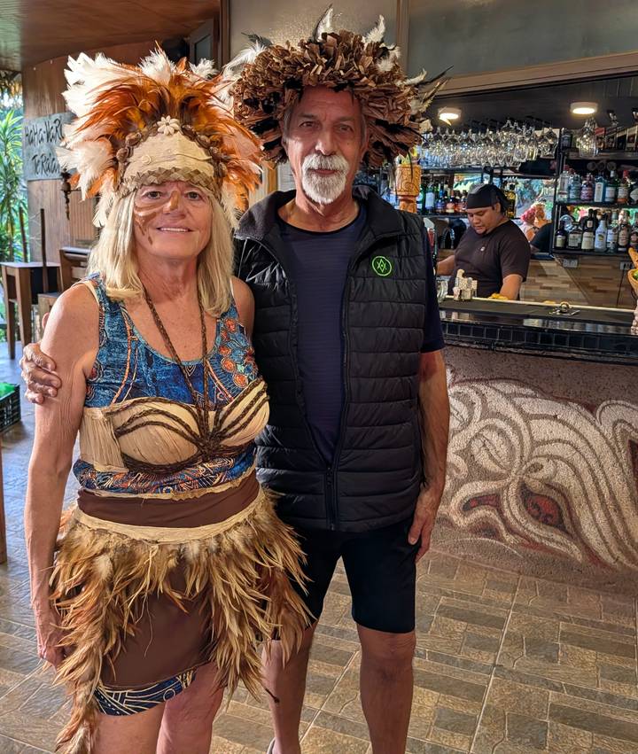 Traveler posing with a local woman in traditional costume inside a café or bar on Easter Island.
