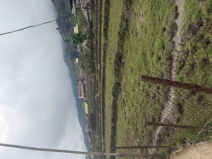Fog-covered rice terraces and scattered village houses in a mountainous rural landscape.