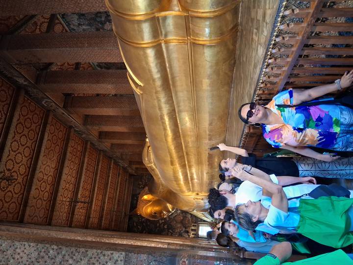 Crowds photograph the golden Reclining Buddha statue inside Bangkok’s Wat Pho temple hall.