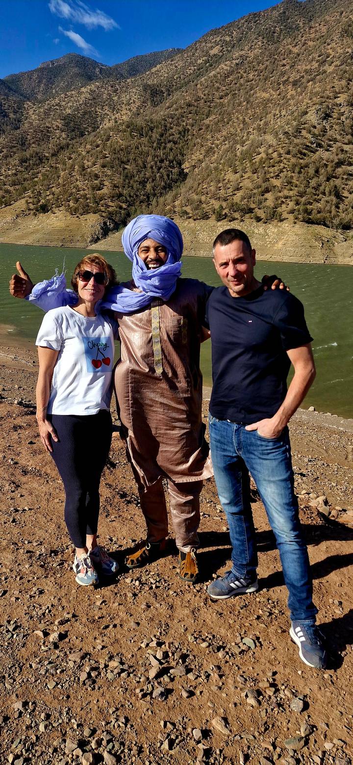 Group of travellers posing together beside a windy desert lake