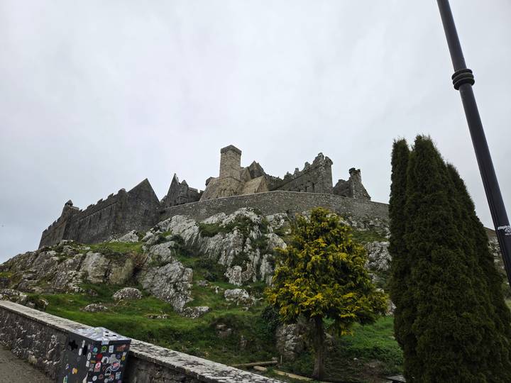 Rock of Cashel fortress rising above rocky hill with cloudy grey sky