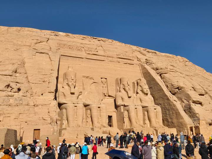 Sun-lit rock façade of Abu Simbel with four seated statues of Ramses II carved into the cliff