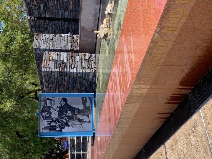 Memorial water feature with photograph of Hector Pieterson and slate walls around reflecting pool