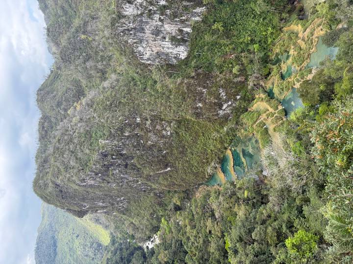Aerial vista of emerald tiered pools and limestone cliffs of Semuc Champey surrounded by rainforest