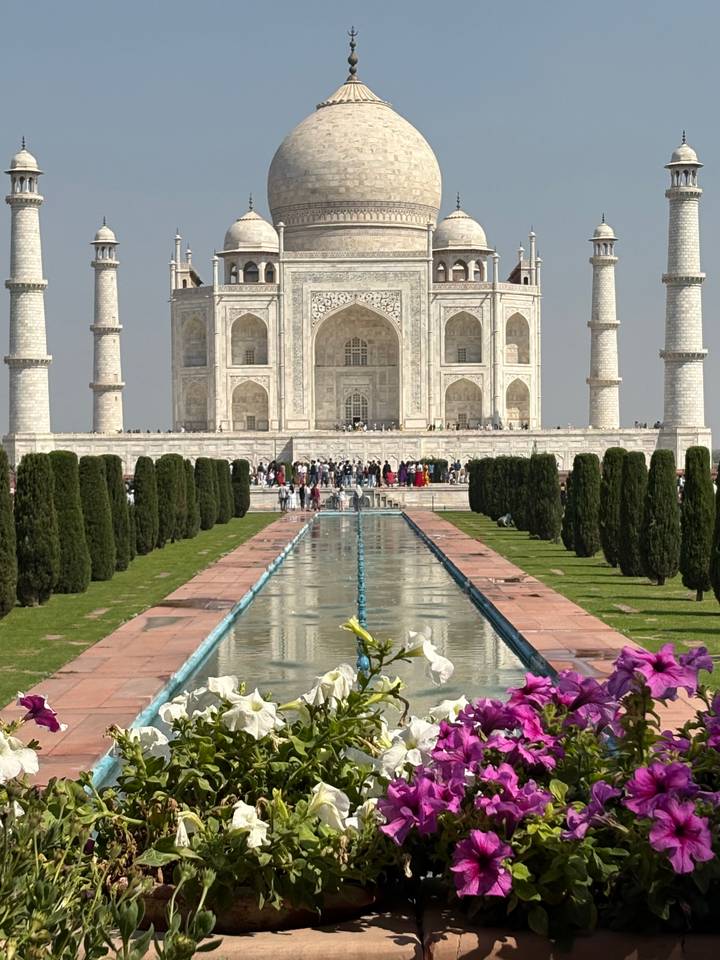 Classic frontal view of the Taj Mahal with reflecting pool and manicured cypress avenue.