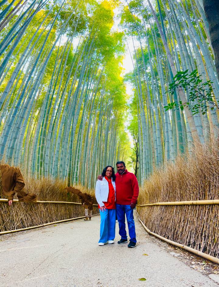 Couple stands amidst towering bamboo stalks of the famous Arashiyama Bamboo Grove.