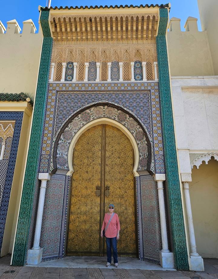 Royal Palace gate with intricate mosaics, green tiles and gilded doors in Fes.