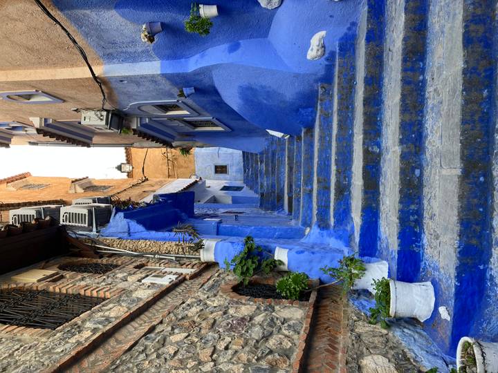 Iconic narrow staircase alley painted in vivid blue tones in Chefchaouen.