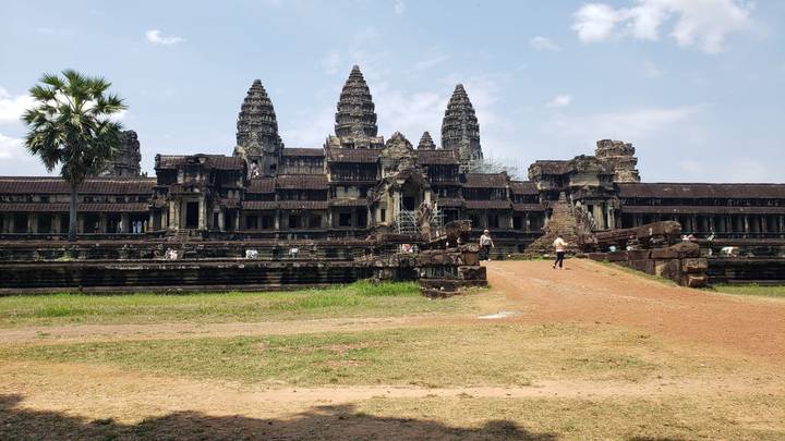 Iconic towers of Angkor Wat rise above laterite causeway as visitors explore the ancient complex