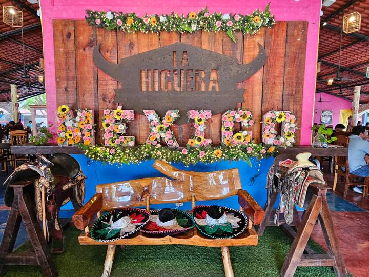 Rustic restaurant display with floral Mexico sign, sombreros, and saddles.