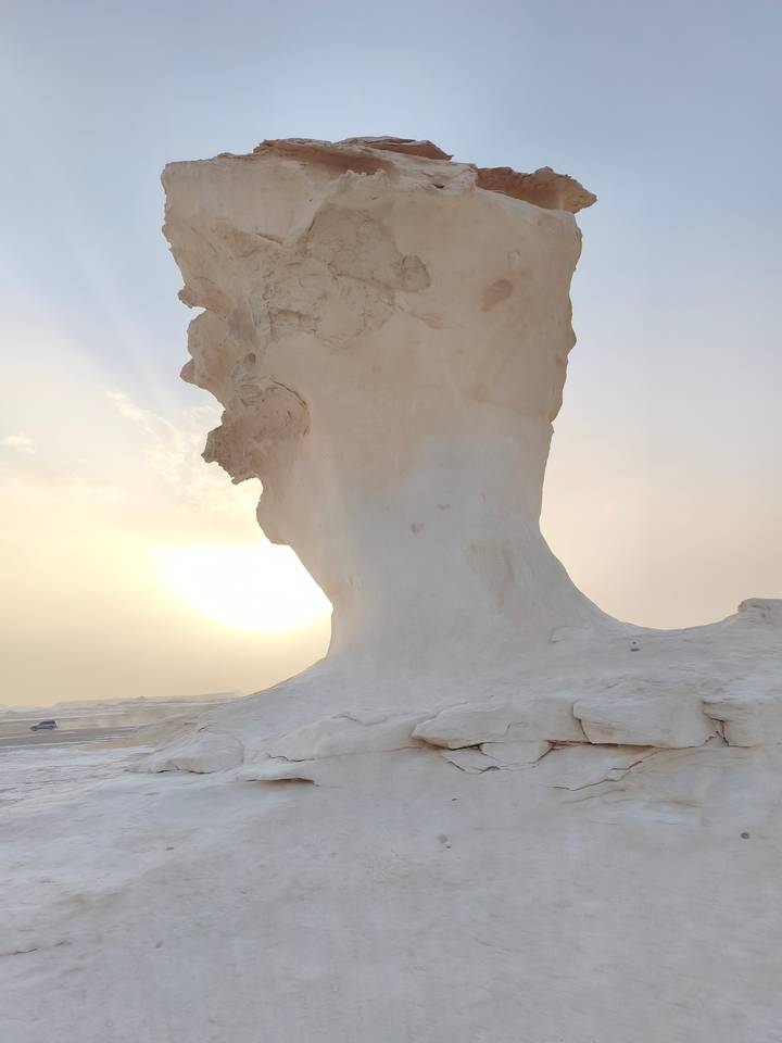 Striking white limestone mushroom rock formation silhouetted against a low desert sun