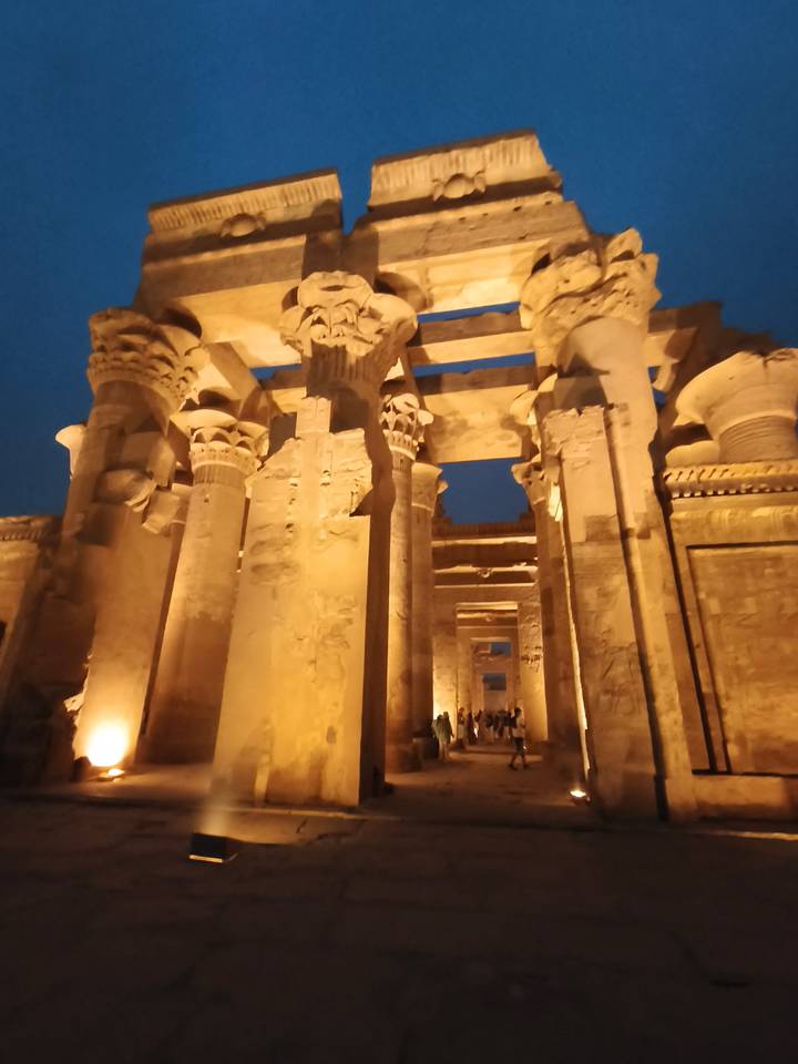 Dimly lit ancient columns and hieroglyphics inside Kom Ombo Temple at night