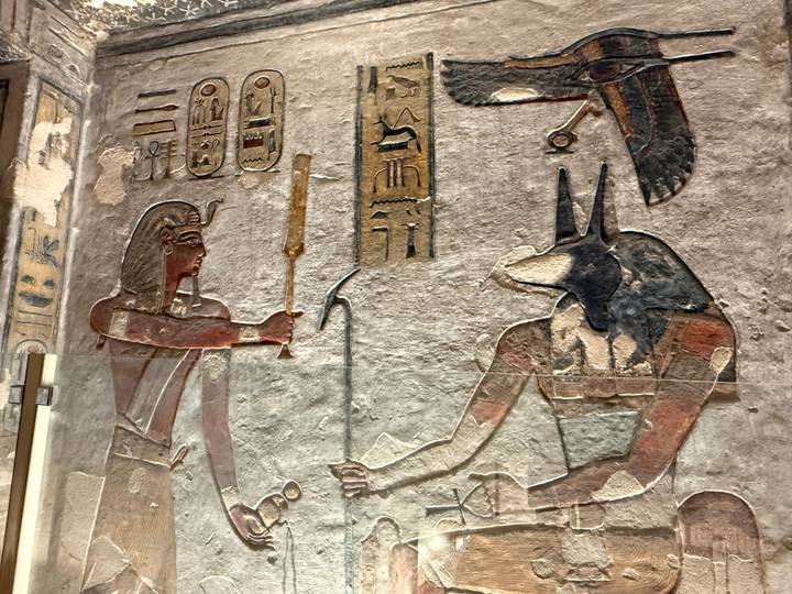 Colourful wall relief showing Egyptian deities and hieroglyphs inside an ancient temple.