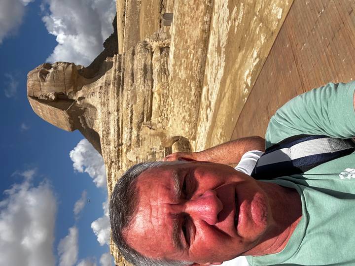 Selfie of traveller in front of the Great Sphinx of Giza under a bright sky