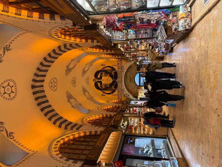 Arched interior of Istanbul’s spice bazaar with warm lighting and stalls selling souvenirs