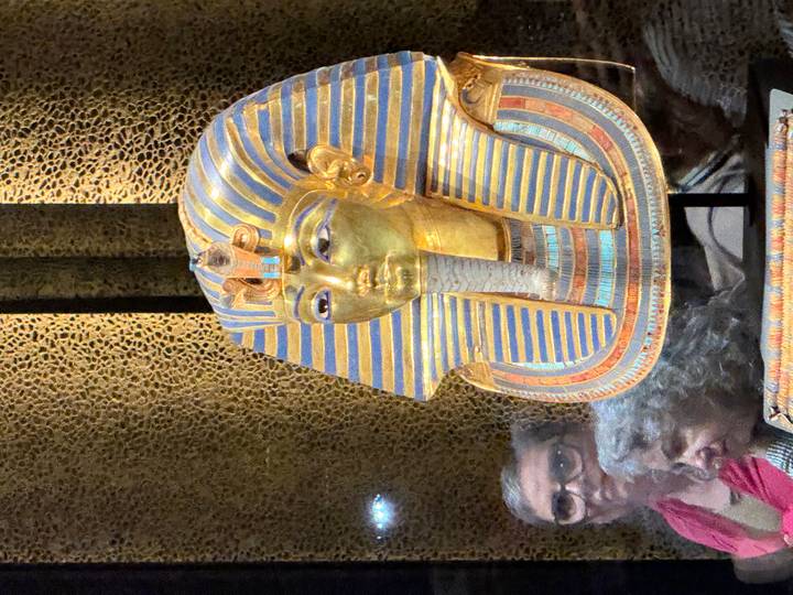 Golden funerary mask of Tutankhamun displayed behind glass in the Egyptian Museum.