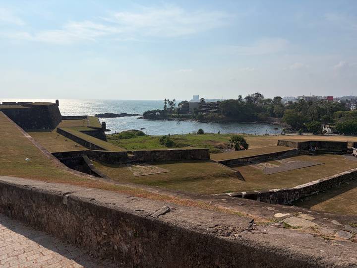 View of Galle Fort ramparts overlooking the Indian Ocean and a rocky inlet.