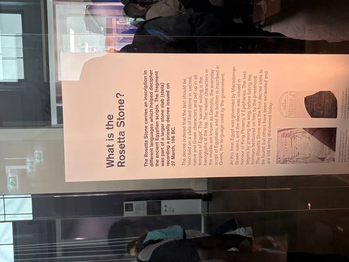Informational museum panel explaining the Rosetta Stone behind glass display