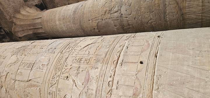 Close-up view of carved stone columns covered in detailed hieroglyphs