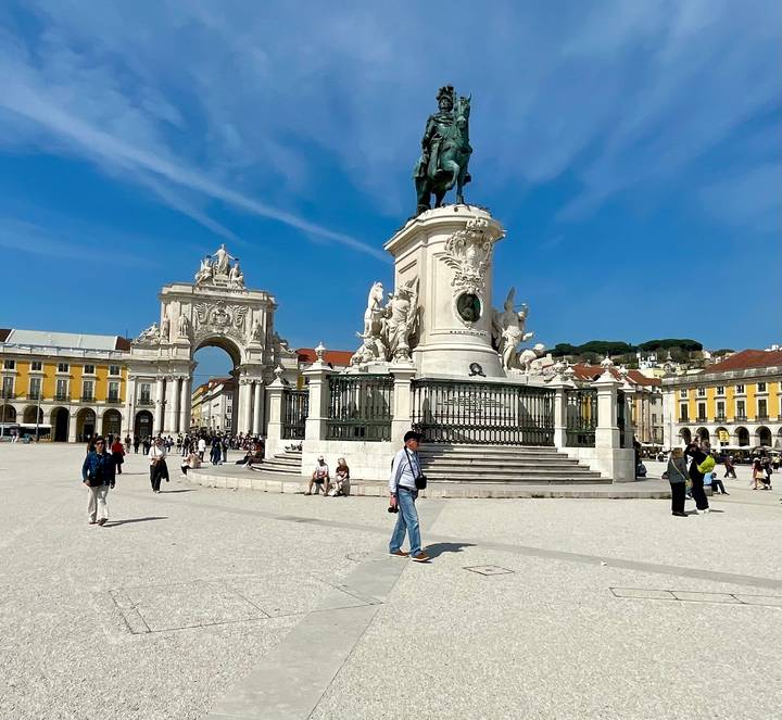 Praça do Comércio in Lisbon with the equestrian statue, Arco da Rua Augusta and visitors enjoying the sunny square.
