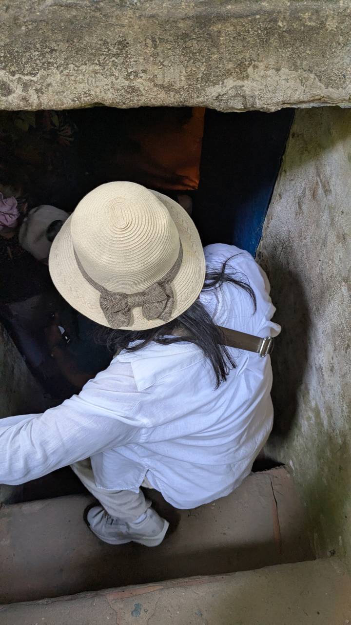 Close-up of a hat and shoulders entering a narrow tunnel; little context visible.