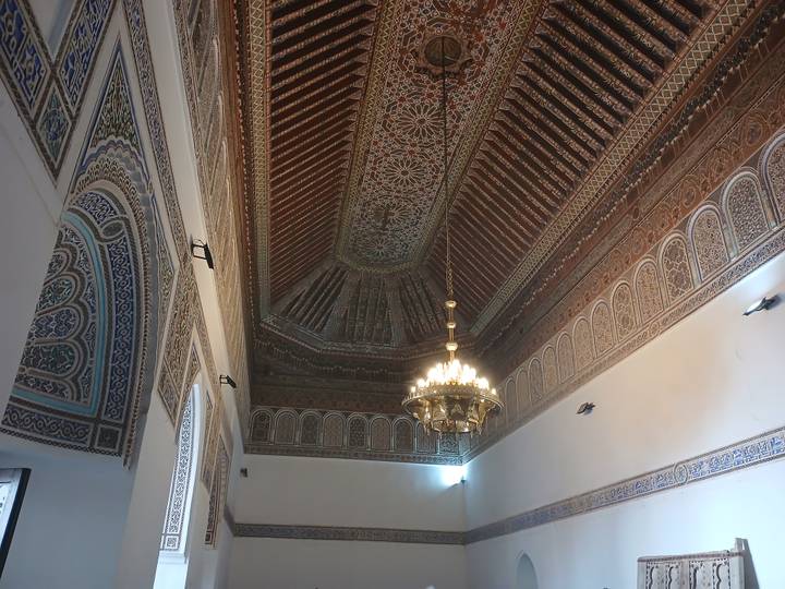 Highly detailed carved wooden ceiling and chandelier inside Moroccan palace