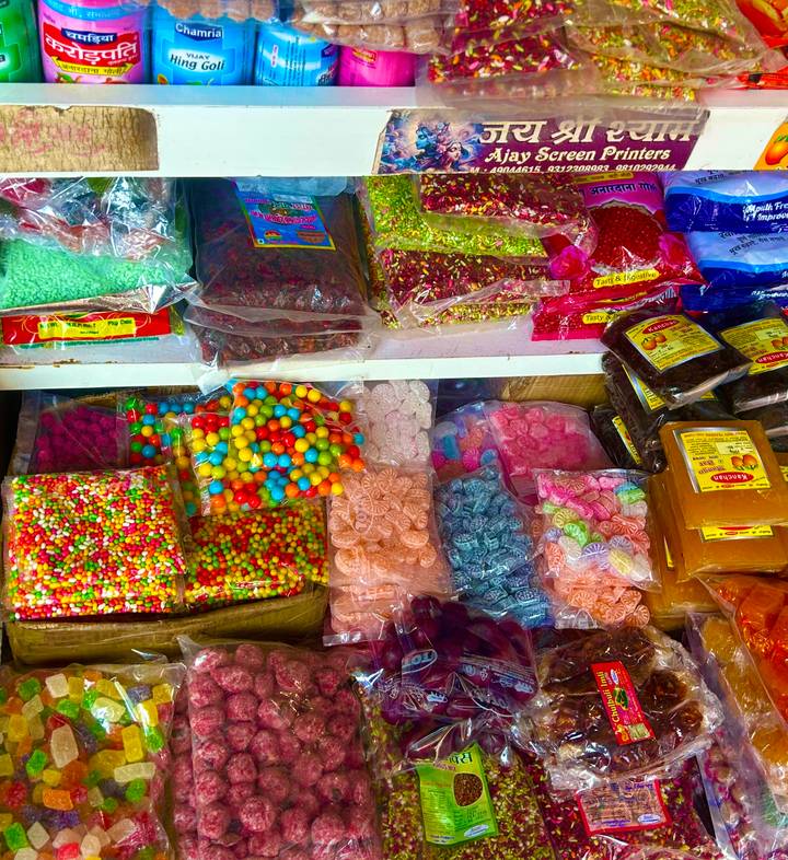 Vibrant assortment of colorful candies and sweets displayed in plastic bags at a market stall.