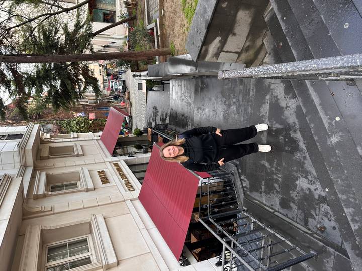Traveller smiling on damp stone steps in a historic Istanbul neighbourhood after rain.