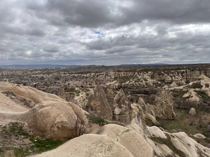Wide panorama of Cappadocia’s surreal rock formations under a cloudy sky.