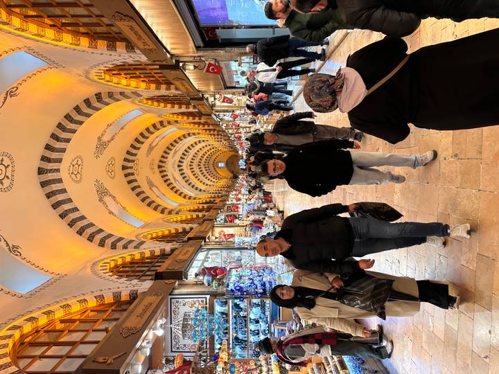 Bustling interior of Istanbul’s Spice Bazaar with glowing arches, shoppers and colourful stalls.