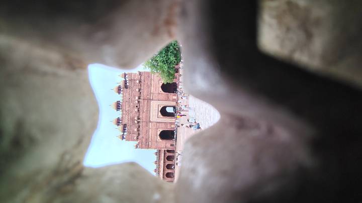 View of Buland Darwaza seen through a jagged stone opening creating a natural frame.
