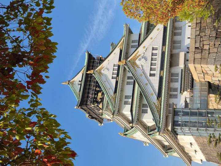 Elegant multi-tiered Osaka Castle with golden accents under a clear sky.