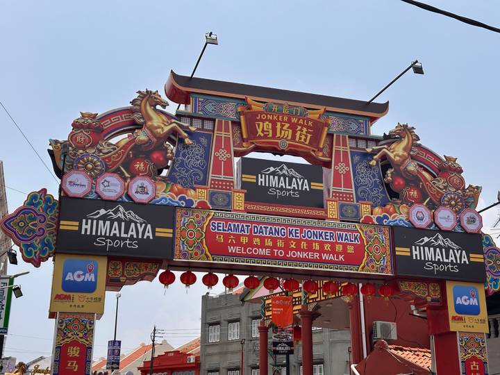 Vibrant welcome arch to Jonker Walk with dragons and lanterns in Melaka Chinatown.