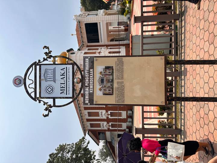 Informational heritage plaque in front of colonial building at Independence Memorial Melaka.