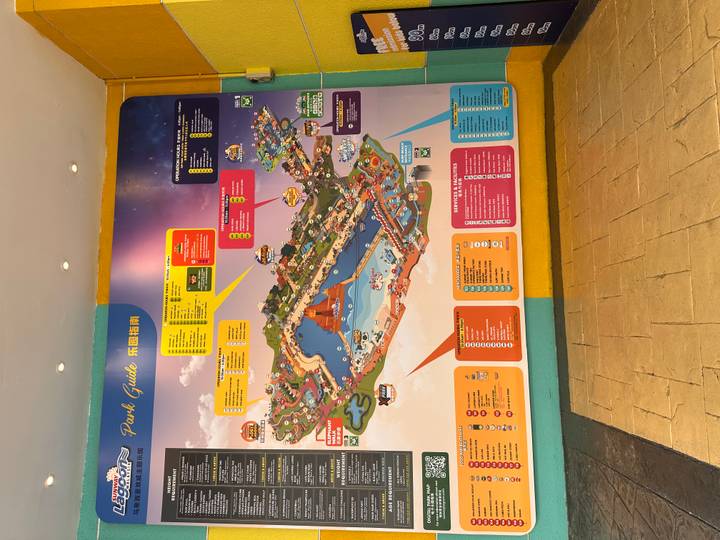 Colorful illustrated park guide map displayed on a wall inside an attraction.