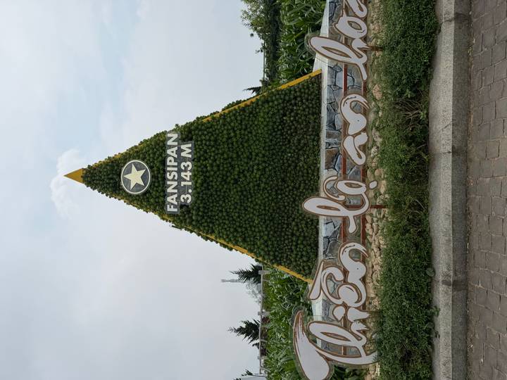 Triangular topiary monument marking Fansipan peak elevation of 3143 meters.