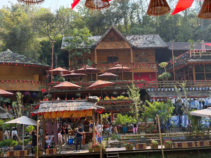 Bustling wooden market complex in Cat Cat Village festooned with red lanterns and umbrellas.