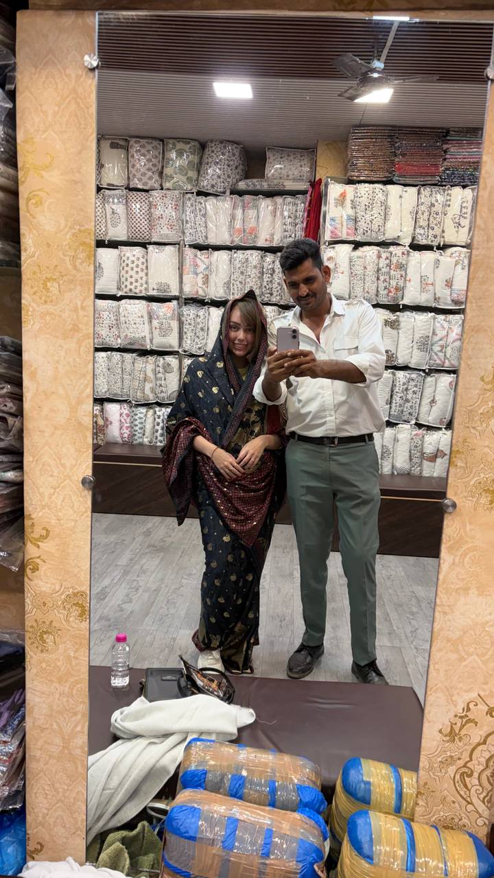 Tourist and local guide take a mirror selfie inside a textile shop