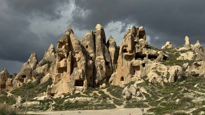 Dramatic fairy-chimney rock formations of Cappadocia under dark storm clouds.