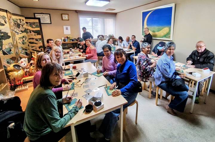 Participants seated at tables during cultural craft workshop indoors