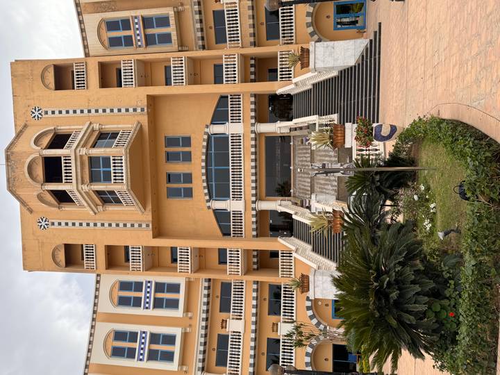 Grand multi-storey hotel entrance with tall staircase and balconies in a Mediterranean style