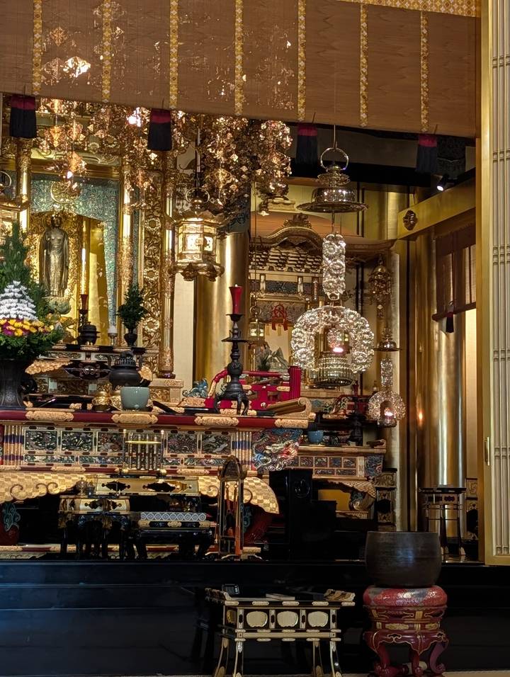 Lavishly decorated Buddhist altar with gold ornaments, candles and intricate carvings