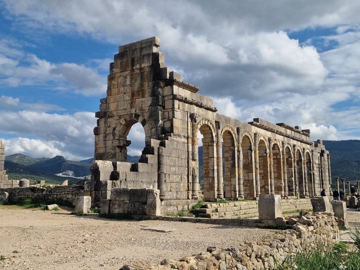 Impressive row of stone arches from the ancient Roman ruins at Volubilis under a bright sky