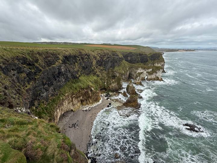 High view over rugged cliff formations and wild Atlantic surf along the Northern Irish coast.