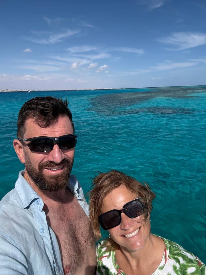 Selfie of a couple on a boat with vivid turquoise Red Sea waters in the background