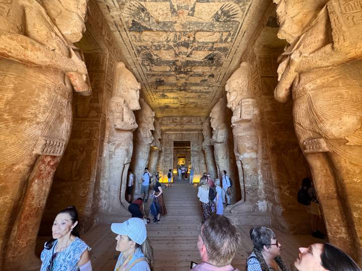Colossal statues line the interior corridor of Abu Simbel Temple crowded with visitors