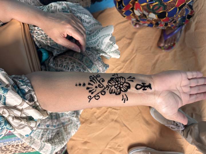 Forearm decorated with fresh black henna design featuring an ankh symbol